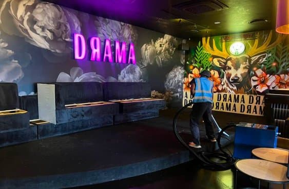 Noir Solutions team member deep-cleaning the Drama Lounge nightclub floor